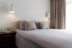 卧室的设计强调空间的灵活性和实用性，讲究从功能性上出发，床头柜两侧的壁灯，适合睡前品读诗书