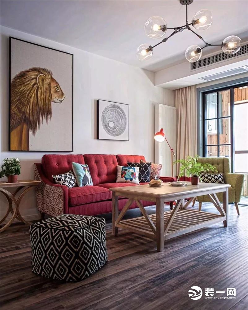 沙发墙上挂一幅狮子头、一幅抽象的铅笔画，结合复古图案的布艺沙发，木质的茶几摆上清新的绿植