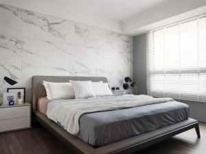 灰色布艺床布置白色床单，墙面大理石的设计整体简约朴素的空间风格，形成了和谐舒适的呼应
