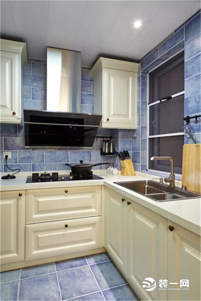 厨房地面与墙面都贴着蓝色仿古砖，结合白色的橱柜，搭配出一个浪漫精致的蓝白配。