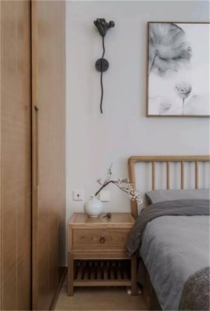 床头柜上面摆放的青花瓷、还有床头的莲花挂画，细节中体现着中式的美与内涵。