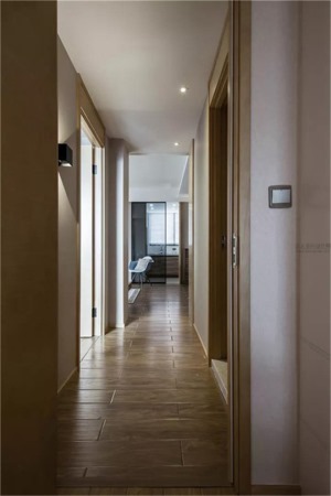 走廊跟客厅、卧室区域贴得一样的地板，整个空间连贯性极强，走廊顶部的内嵌筒灯，按狭小的空间也搭配得效果