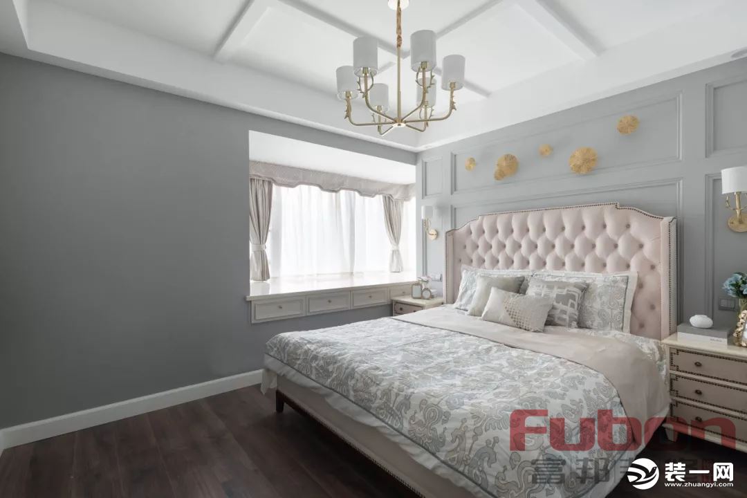  主卧以灰白两色为主要色调，奶茶色的床及床头柜温馨优雅，床品与墙面的浅灰色系相呼应。