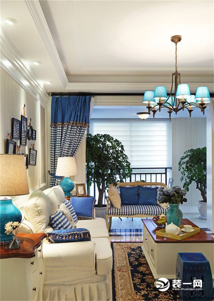 有点地中海元素的湛蓝色方格窗帘 和抱枕、沙发坐垫相呼应，乳白色布艺沙发搭配欧式印花地毯