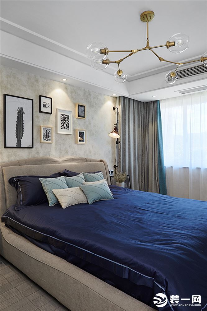 房间采用米黄色底纹墙纸，配上错落有致的装饰画以及风格独特的床头灯，更具有温馨气息。