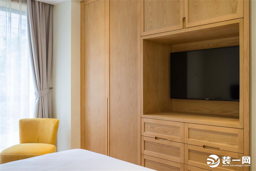 次卧将电视柜与衣柜合二为一，床尾放置单人沙发椅，为来访客人提供惬意的午后好去处。