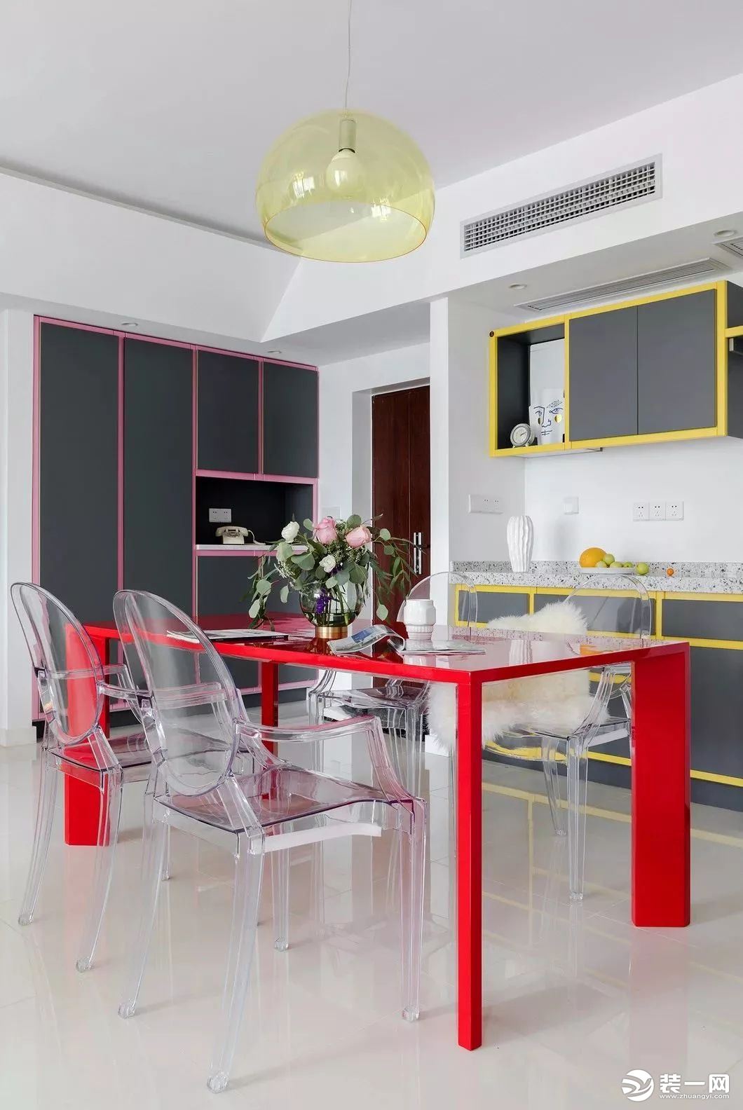 厨房和餐厅的用色大胆了许多，浓度亮度较高的黄色吊柜、粉色的储物柜、鲜红色的餐桌，形成了鲜明的对比，