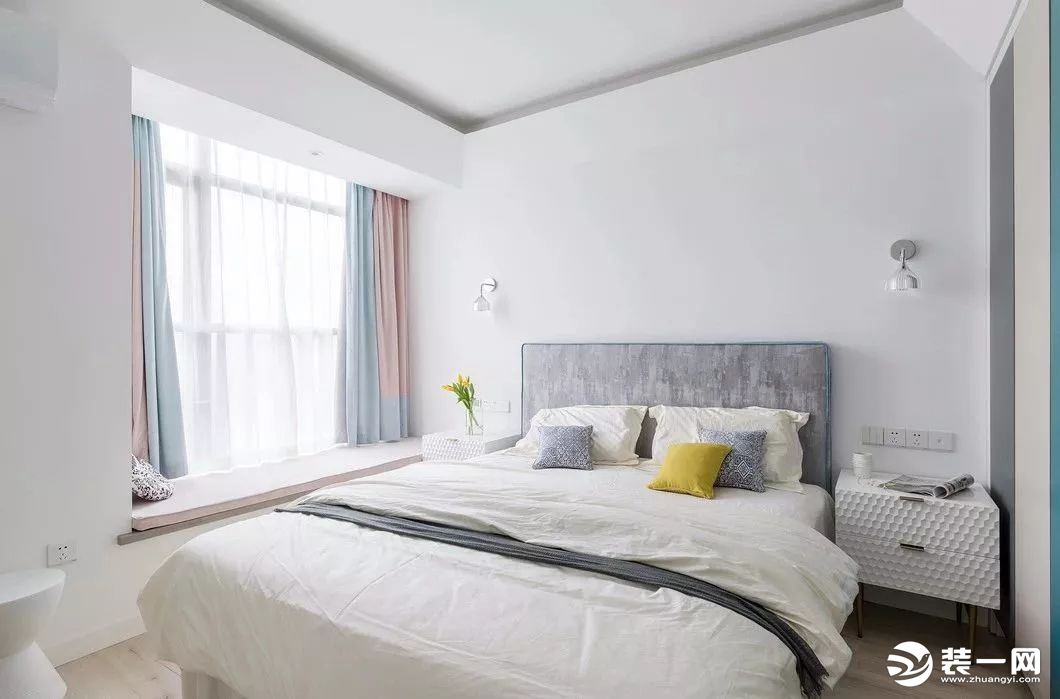 主卧配色延用了客厅的色彩，简约的设计却不简单。双色窗帘是亮点，床上用品选用的是米白色，给人一种温暖