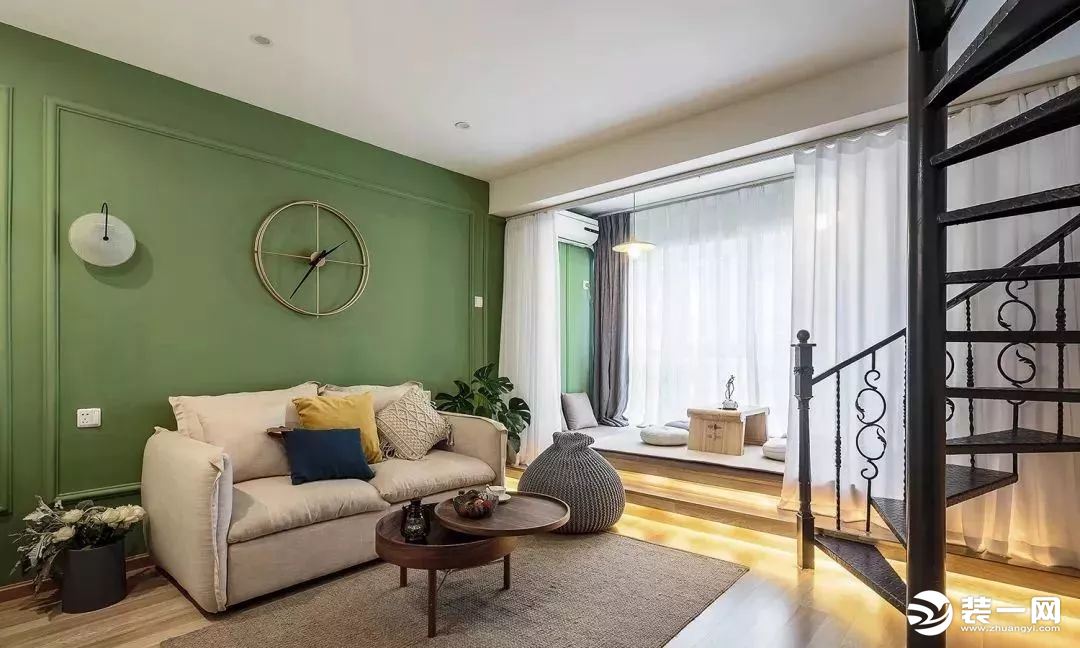 客厅，沙发背景墙是复古一些的绿色，还做了石膏线装饰，简约却很有格调，搭配杏色的布艺沙发，还有小盆绿