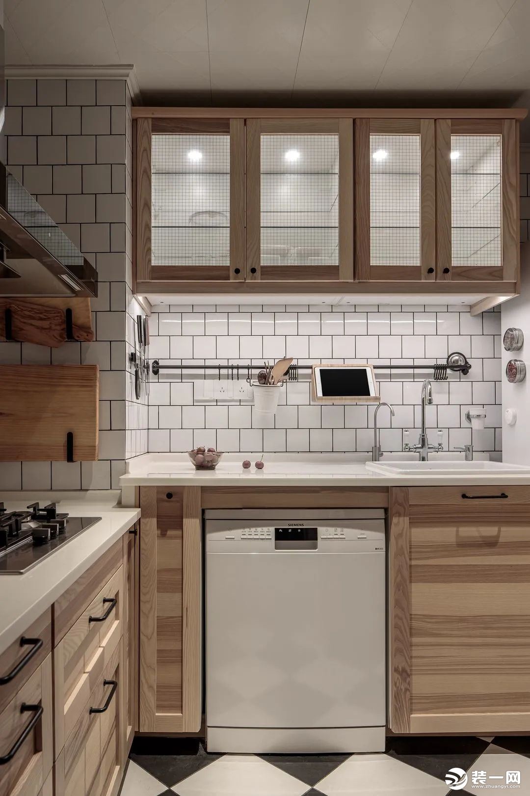 厨房以白色为主调，搭配木色和黑色，简约自然又不单调。常用厨房用具收纳于墙面，维系操作台的整洁有序