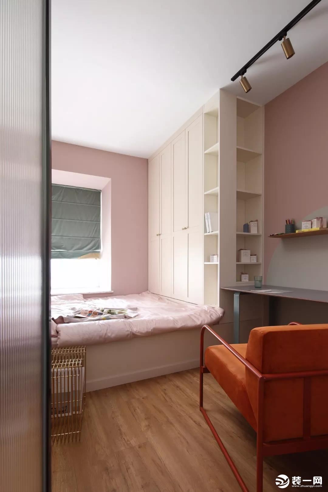 次卧的墙面和软装也同样是选择了粉色的，榻榻米床组合衣柜和书桌的设计可以满足屋主平时使用的需求，也增加