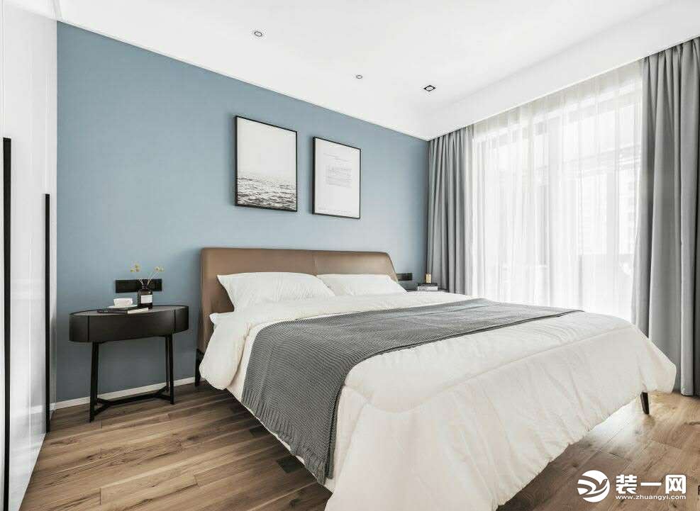 次卧的床头背景墙采用蓝色.搭配棕色的皮质床和原木地板.整体空间简约而充满精致感 