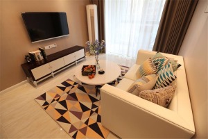 米白色的大理石茶几和简单的布艺沙发，使整个客厅多了几分素净感。不规则的几何地毯，大胆的撞色拼接。
