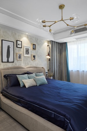 房间采用米黄色底纹墙纸，配上错落有致的装饰画以及风格独特的床头灯，更具有温馨气息。