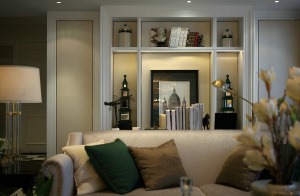 先来一张客厅的细节照。香槟茶色的沙发充满质感。沙发后面是一个精致的书架。整个搭配非常的优雅大气。