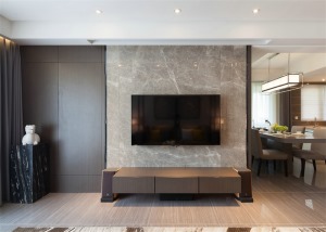 现代风格的客厅，电视墙拥有大面积的石材墙面成为空间的焦点，配饰上黑色的玻璃显得格外高端。