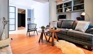 客厅是全家人活动的重心。全室采用温暖的木地板搭配简洁白墙，墙面的木作收纳皆以浅灰色为主调.