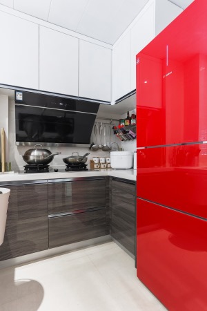 用黑白跳色橱柜搭配米白色瓷砖让厨房整洁而又清新明亮，红色的冰箱又带有不一样惊喜。