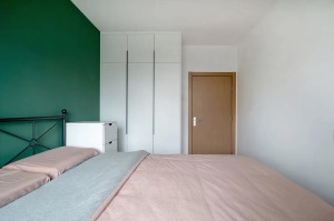 5卧室非常简约，背景墙与常见的设计有所不同，采用分色处理。粉色和绿色比例为3：1，墙面粉色又与床品相