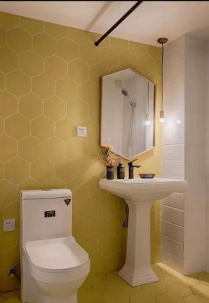 卫生间也选择了和厨房呼应的明黄色，六角蜂窝砖属于自带几何感的设计，可以让小空间在视觉上得以延伸、扩