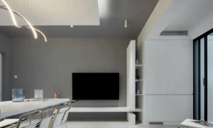 ▲ 电视背景贯穿客餐厅，纯粹的灰色墙面搭配白色柜体，家具颜色在选择上也保持统一，显得空间尤为整洁
