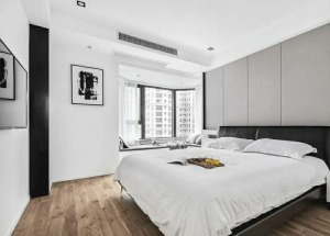 主卧的床头背景墙采用硬包设计.黑色的皮质床搭配.原木地板.使得空间优雅而更高级