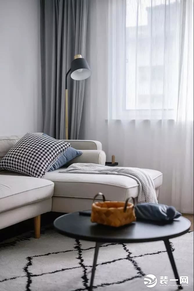  米白色的L型布艺沙发柔和而内敛，线条感极强的落地灯，洋溢着极简主义的浪漫。