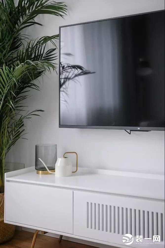 电视背景墙没有多余的修饰，电视柜线条简洁又不乏设计美感，富有生命的绿植给予空间更多的活力与生机。