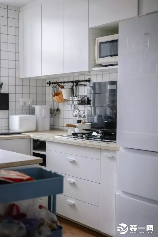  厨房整体都选用了白色为主色调，构造一个纯净明亮的空间，局部配以黑色家电与厨具，撞色的同时又平衡的恰