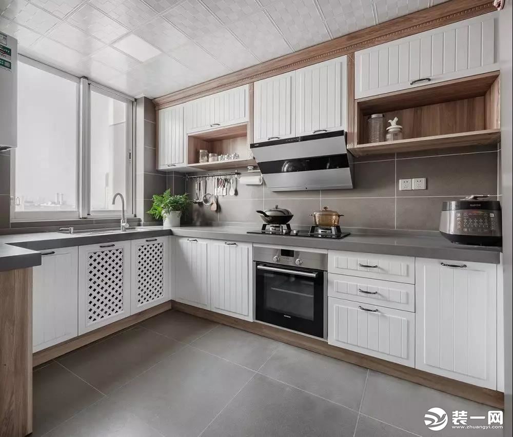  厨房以白色和原木色为主调，大面积的橱柜增加了储物空间，整体干净明亮又不乏烟火气。