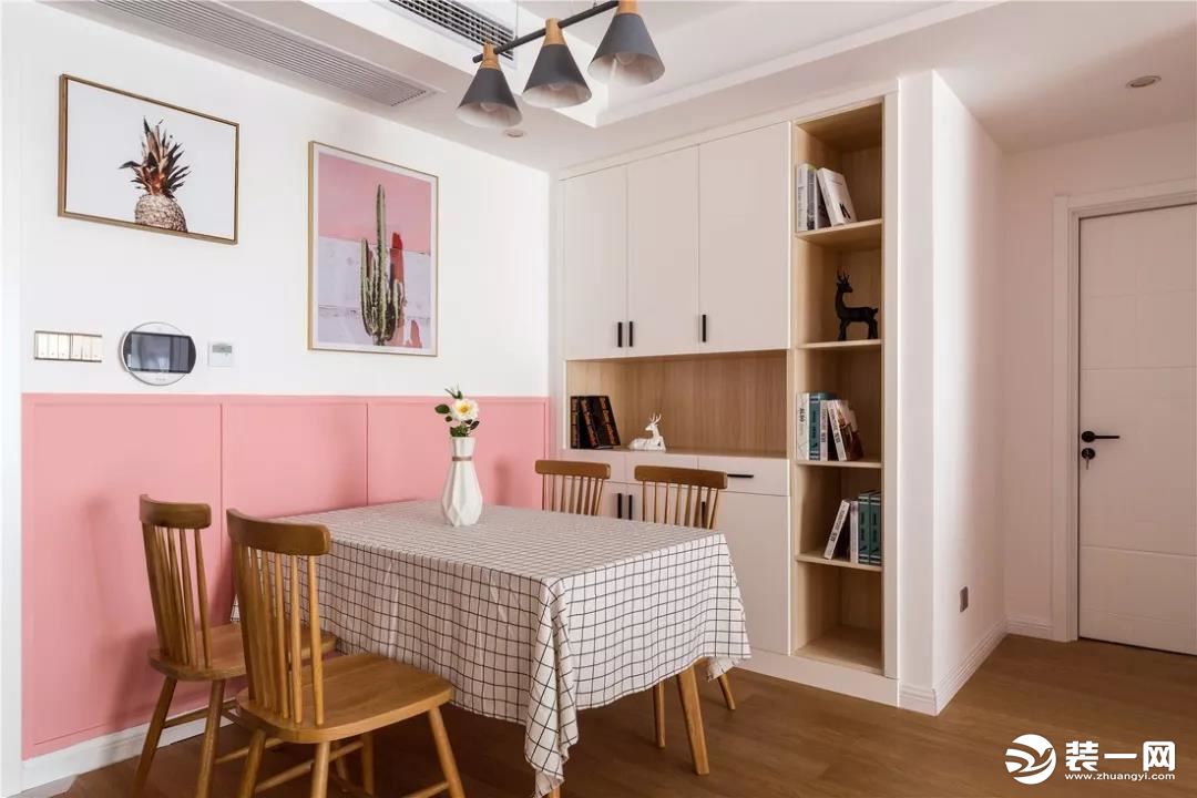  餐厅也与客厅保持统一，用粉色半护墙贯穿整个空间，定制柜子增加收纳空间，加入原木色给予用餐空间以温馨