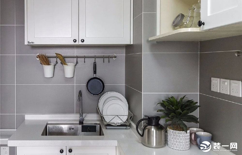 厨房墙面设置挂杆，让厨具有个便于取放的收纳之处，灰色基调搭配白色的橱柜，让烹饪氛围简约又轻松。