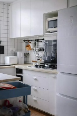  厨房整体都选用了白色为主色调，构造一个纯净明亮的空间，局部配以黑色家电与厨具，撞色的同时又平衡的恰