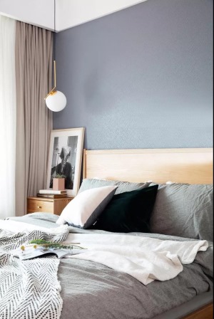 圆润精致的灯具，温润自然的木质大床与床头柜，在简约内敛的灰白底色下蕴藏着一份纯净与温馨。