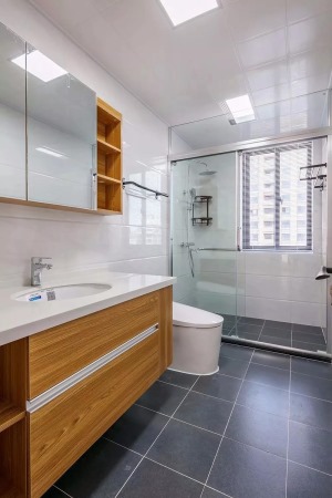  卫生间灰色地砖与白色墙砖搭配，在通透的玻璃隔断下，整个空间都显得简约而干净。