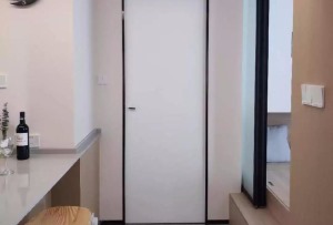 过道尽头是卫生间的门，黑色边框提升精致度，看起来简洁又舒适