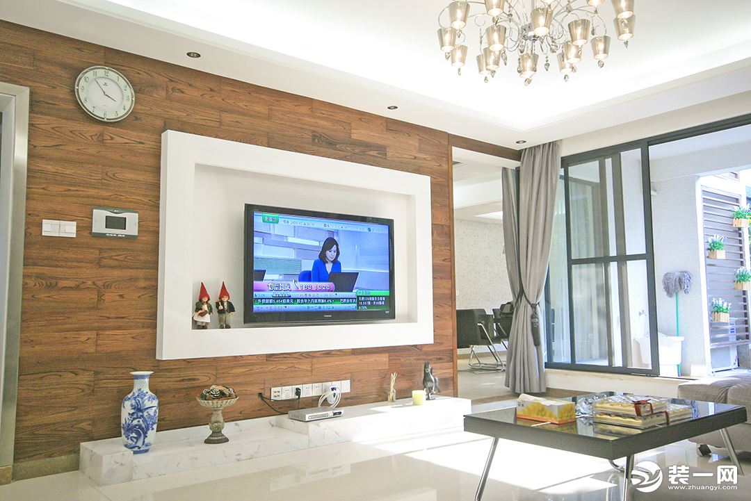客厅是典型现代风气息，时尚、大气、简约。电视机实木背景墙面积恰到好处，不会使室内显暗，反而增加了温润