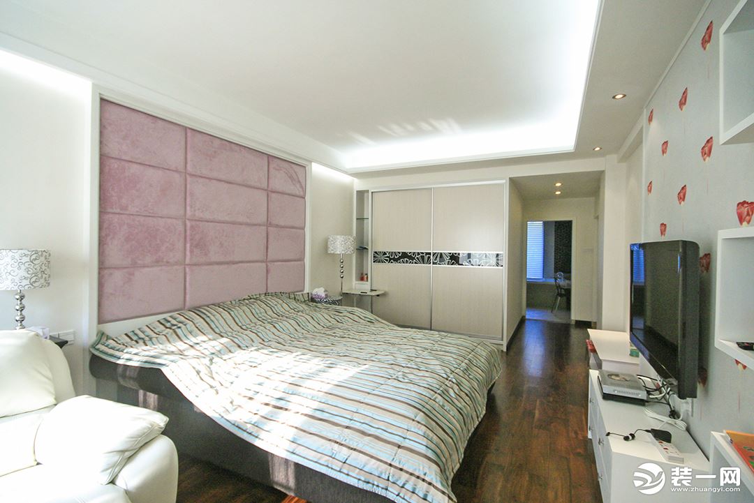 糅合了床头软包背景墙的淡粉色和电视机背景墙的彩花，使空间变得温馨舒适。