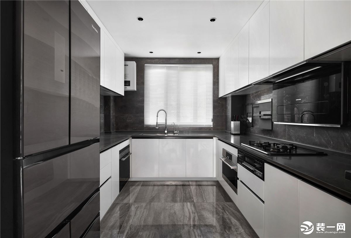 黑色台面和墙砖与白色柜门形成对比，为厨房增添冷静的质感，U型的橱柜充分利用了空间，让操作更加方便。