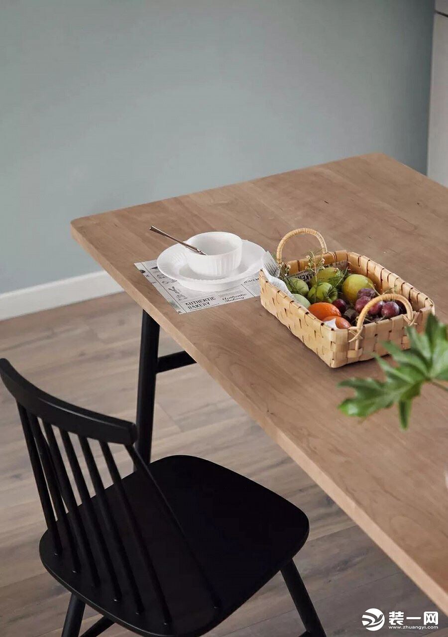 原木纹理的餐桌搭配黑色温莎椅，简单质朴的餐具与编织收纳自然点缀。