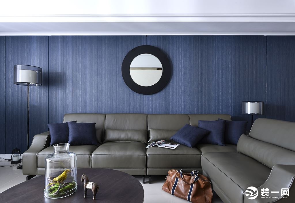 深灰色沙发皮质工艺，舒适柔软，蓝色的沙发背景墙，色彩的克制运用，营造出一个干练的空间观感。