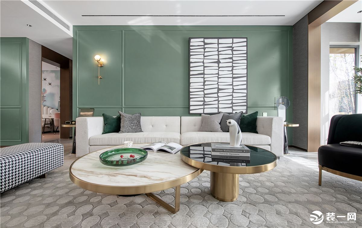 沙发墙以淡淡的茶绿色为背景，加入边框造型，挂一幅抽象派的灰白色装饰画，搭配米白色的布艺沙发，让空间充