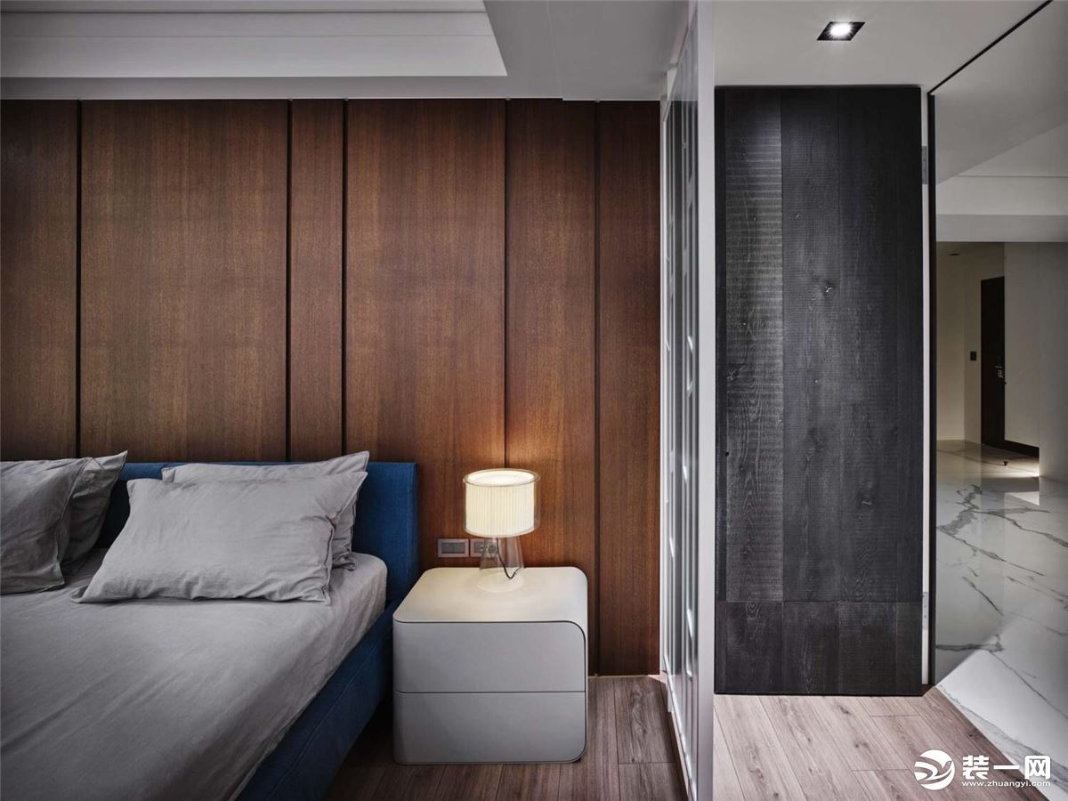卧室不在是洁白的空间，深色原木与灰色的搭配，床头的小台灯，为这个空间带来温馨与舒适感。