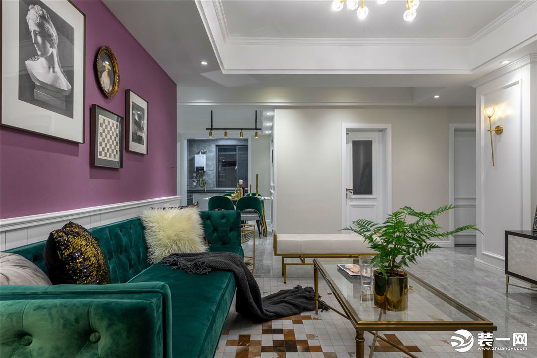 客厅以深紫色为背景色，搭配复古绿的沙发，与背景墙上的艺术画框，带有浪漫的格调
