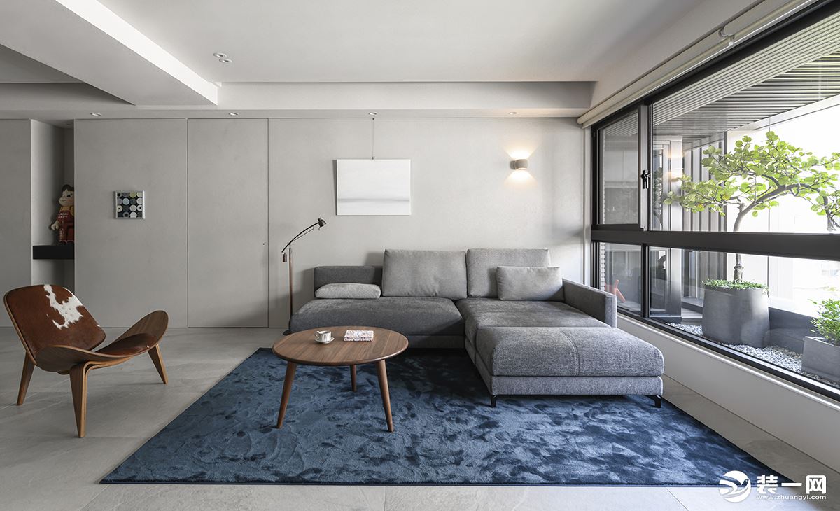客厅以白色为主基础色，搭配上柔软的灰色布沙发，蓝色的细绒地毯，赤脚踩上去，也很舒适。