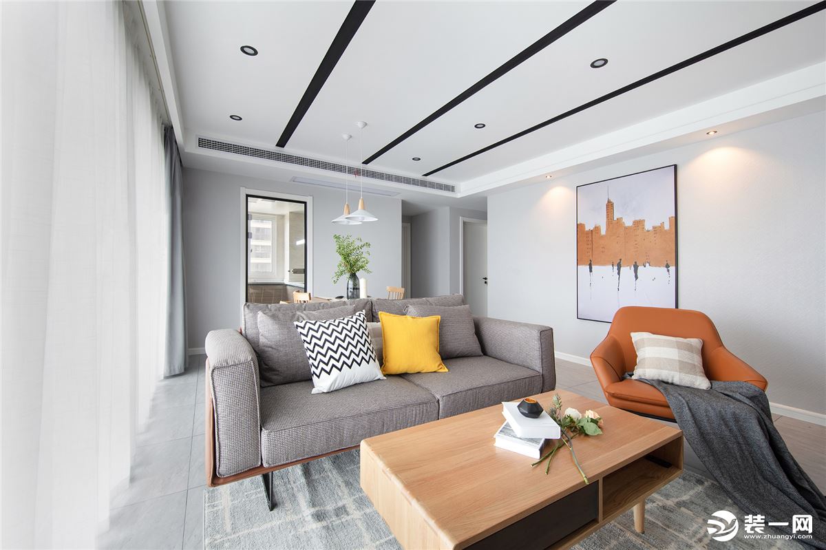 客厅用灰色系作为主要的基调，格子纹样的地毯既是一种点缀，又能放大视觉上的空间效果。黄色的皮质单椅与背