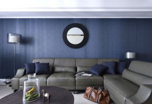 深灰色沙发皮质工艺，舒适柔软，蓝色的沙发背景墙，色彩的克制运用，营造出一个干练的空间观感。