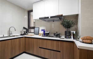 厨房以偏暖色调为主，米色背景墙搭配白色的台面，原木的柜体，空间的色彩融合，耐看而舒适。