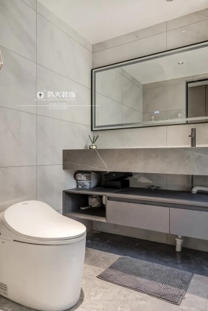卫生间以浅咖色的地面墙面砖设计，整面墙的洗手台及储物，提供了一个简雅舒适而实用的卫浴空间