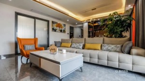 客厅空间以精选橙色单人沙发作为跳色，配上极简的一字型沙发，相映成趣，形成了高雅简约的格调